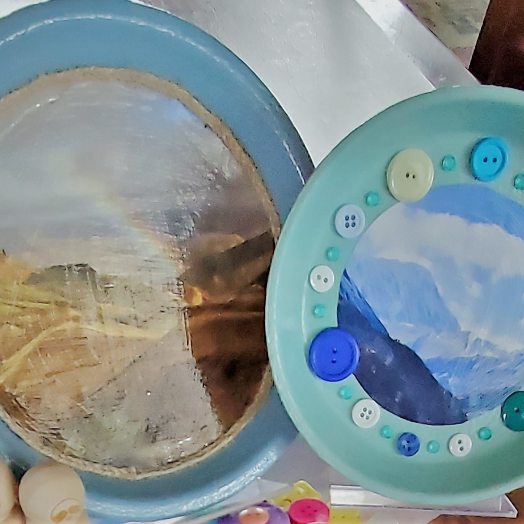 Flower pot saucers painted and decorated with a photo and buttons that have been glued on.